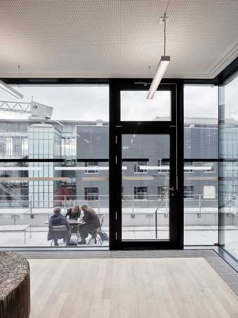 alt=ML, Student Project House Zentrum, schwarz-weisser Gegenlaufschutz an Glasfront von Aufenthaltsbereich zu Dachterrasse