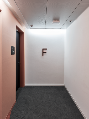 STF, Stampfenbachstrasse 114, Stockwerkangabe in Korridor, dreidimensionaler Buchstabe, Seiten lachsfarbig wie Wand lackiert, Front schwarz matt