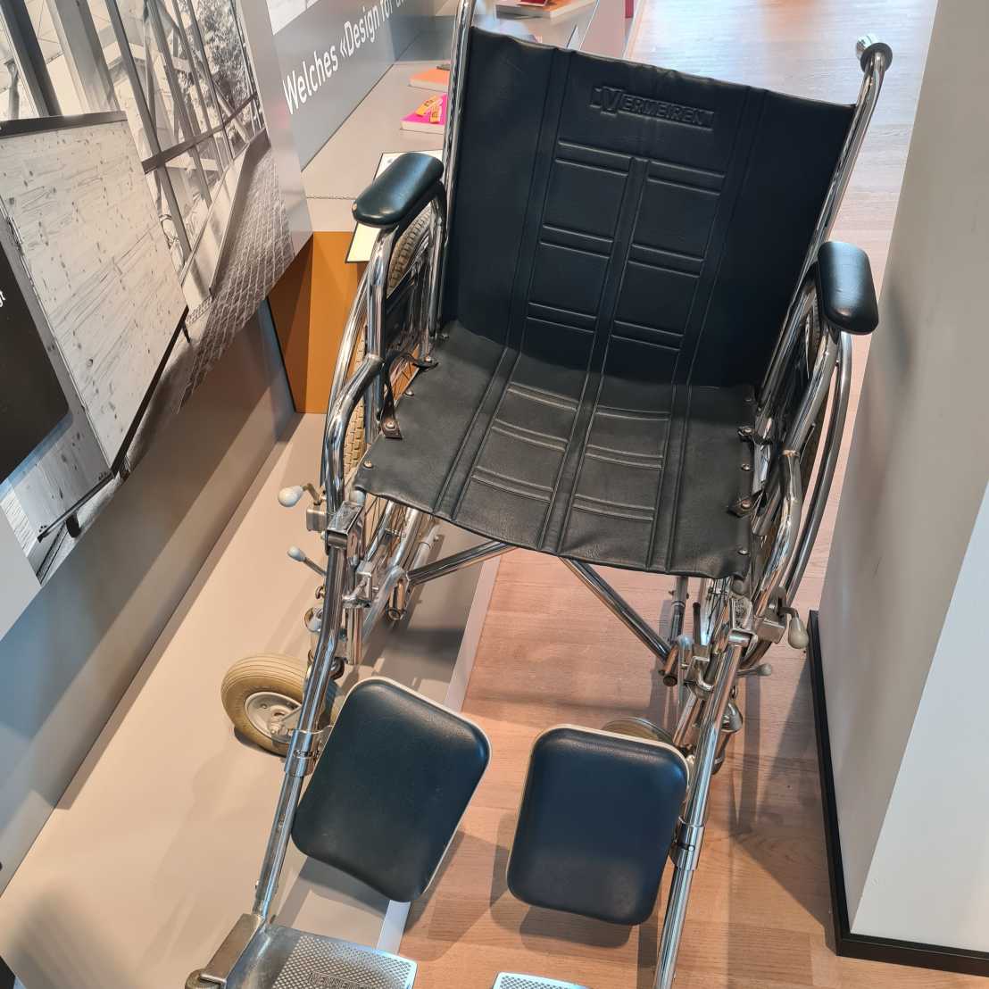A wheelchair stands next to a pillar in the exhibition