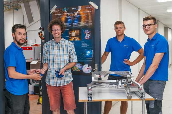 The three polymechanics hand over their workpieces to Urs Grob, the technician in the Spin Physics group