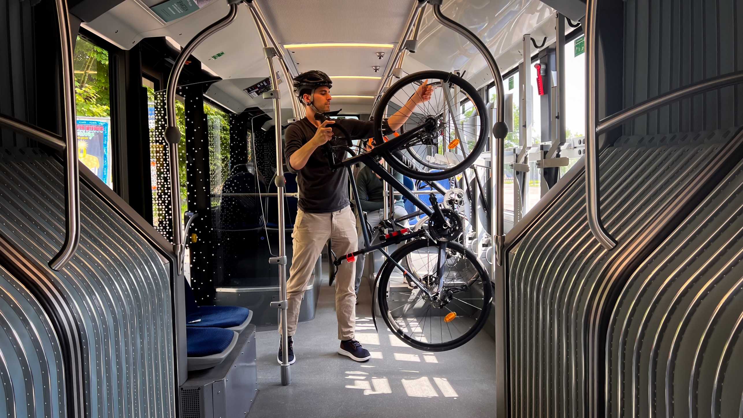 Man stands with his bike in the bus and has set it up. 