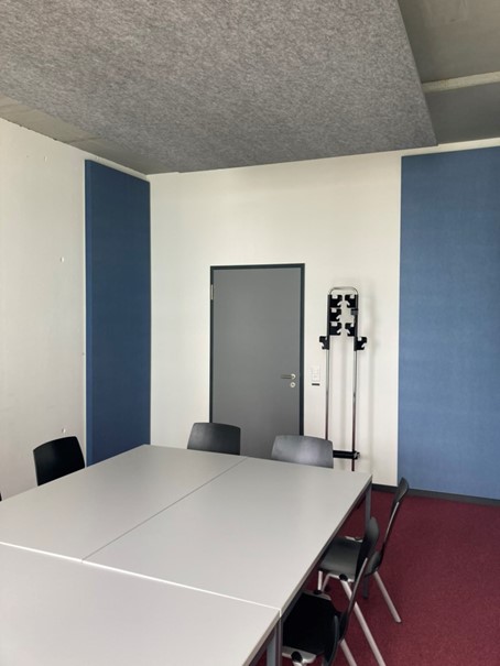 Enlarged view: Meeting room HCP G 34.3, newly equipped with a grey ceiling sail and blue wall absorbers in three corners of the room.