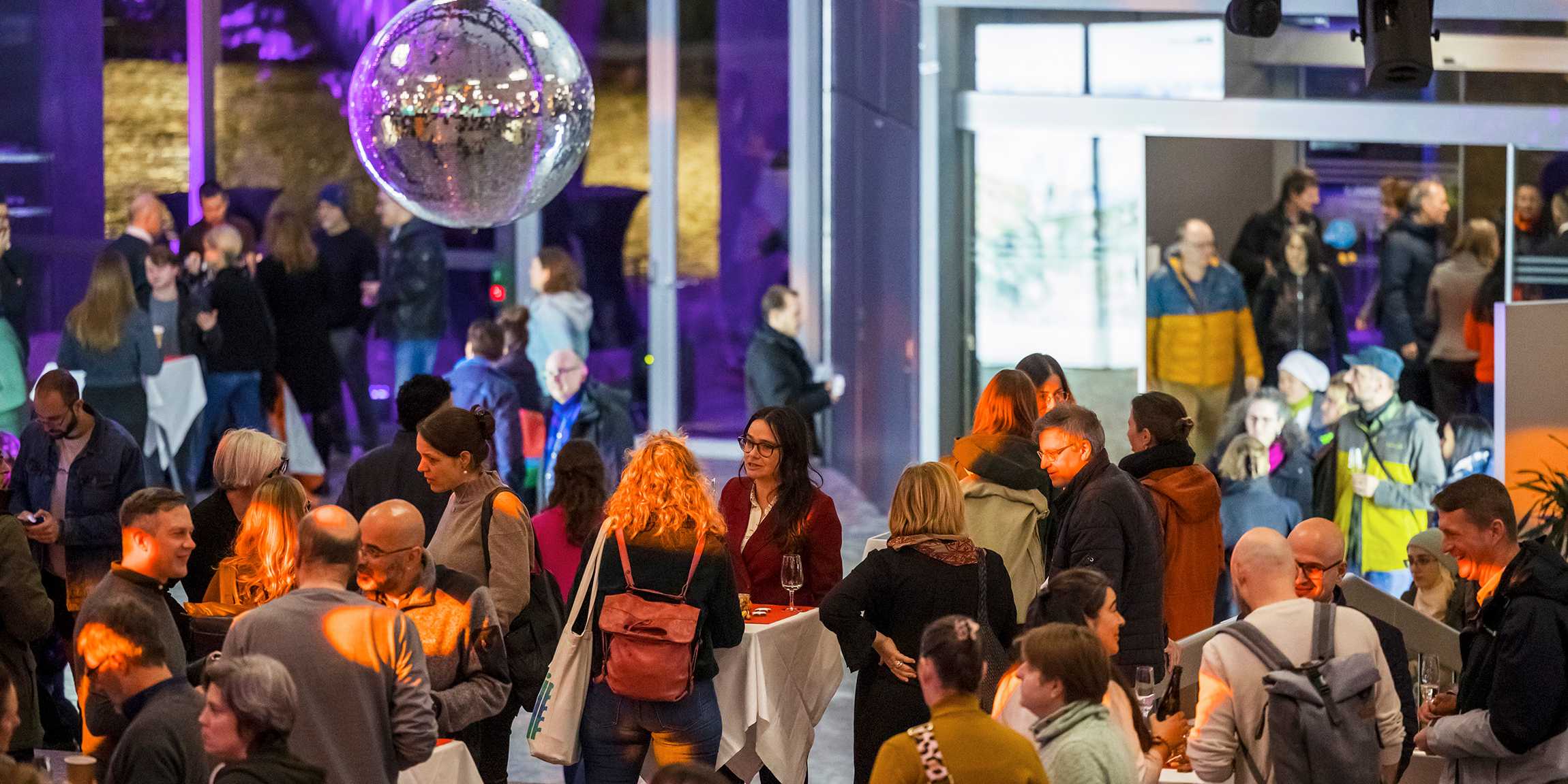 A disco ball hangs over the packed hall