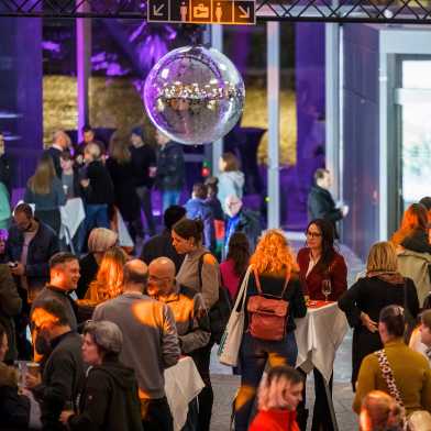 A disco ball hangs over the packed hall