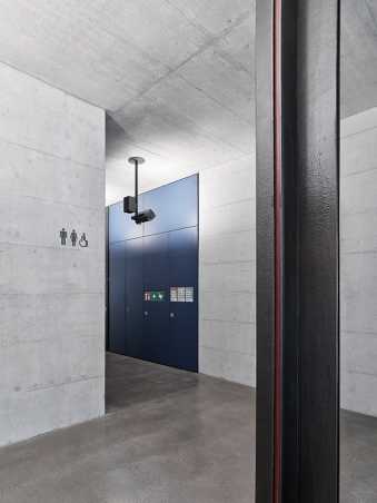 GLC, Gloriastrasse 37/39, WC pictograms as three-dimensional metal shapes, painted dark grey metallic, mounted on exposed concrete
