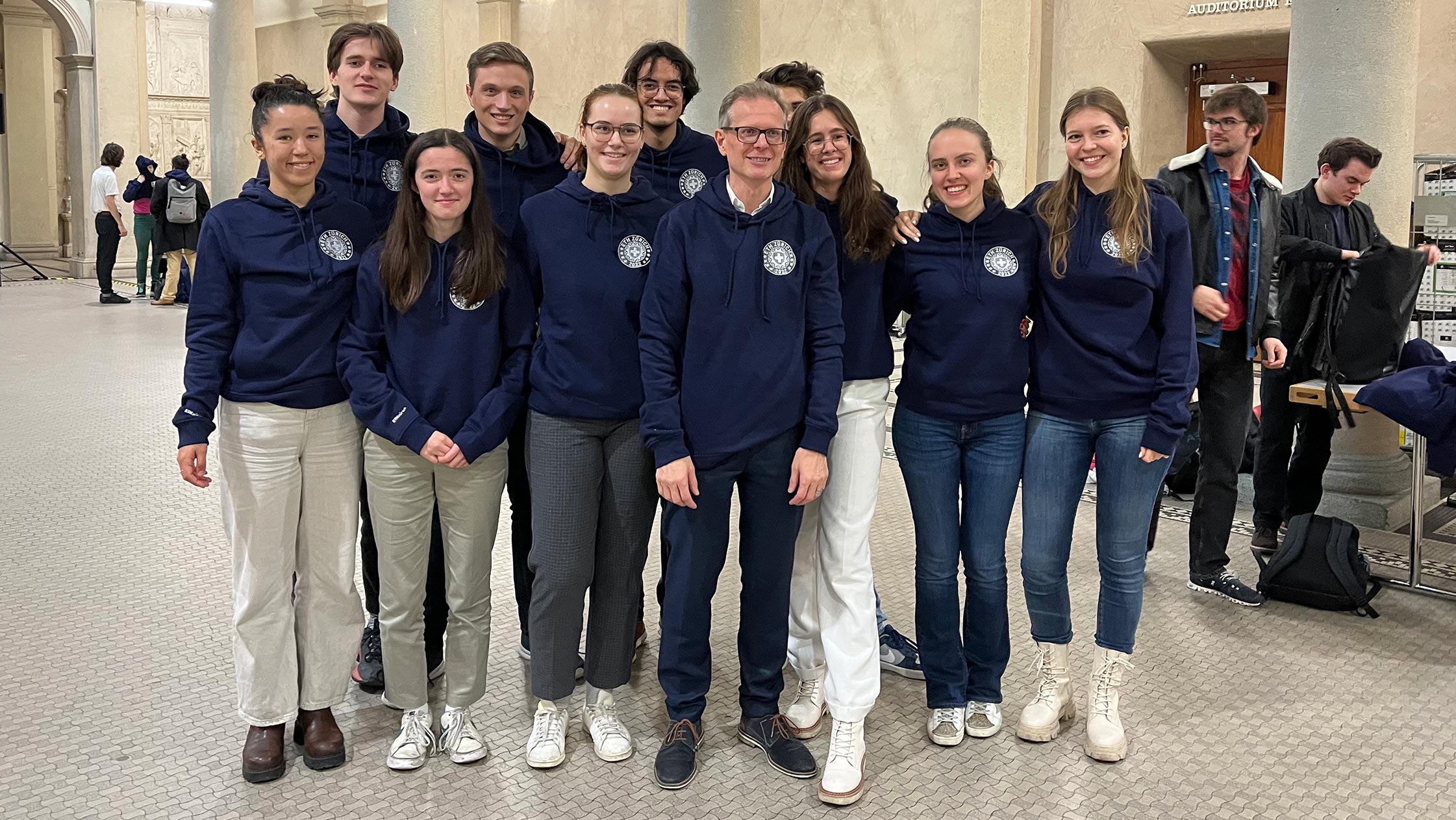 Rector Günther Dissertori and ETH students wearing the first-year examinations hoodie